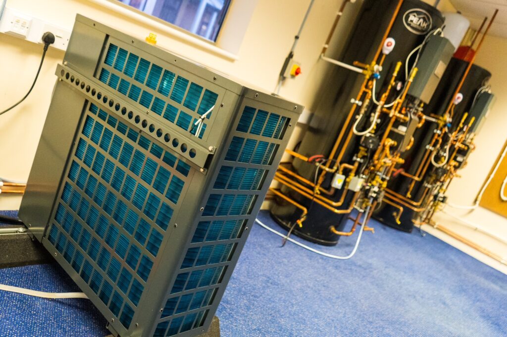 air source heat pump in foreground and cylinders in background